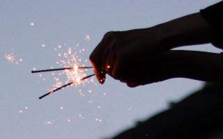 Sparkler holding person starry sky - a sky background behind them free wallpaper