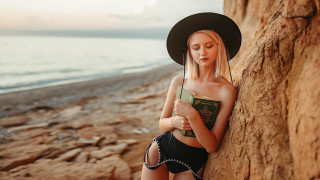 Woman hat beach reading ocean - leaning free wallpaper