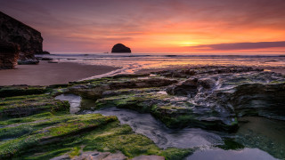 Rocky beach water sunset formation - a rock formation in the foreground free wallpaper