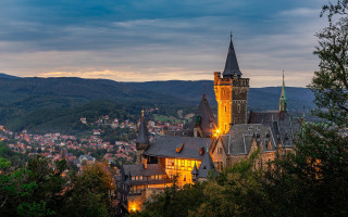 Castle clocktower night mountainside city - a clock tower free wallpaper