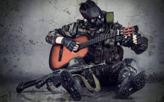 Man gasmask playing guitar sitting - his hand free wallpaper