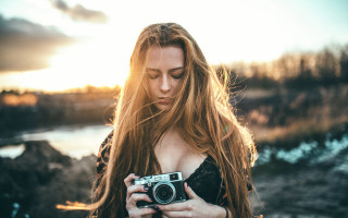 Woman holding camera blonde sunset - long hair holding free wallpaper