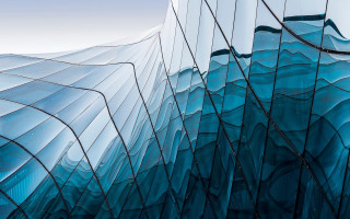 Curved glass facade blue sky - a blue sky background free wallpaper