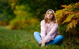 Woman sitting field blurry nature 2 - the ground in a field of grass free wallpaper