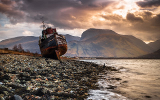 Rocky beach boat mountains sunset - a rocky beach next free wallpaper