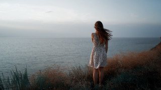 Woman cliff ocean wind dress - her back free wallpaper