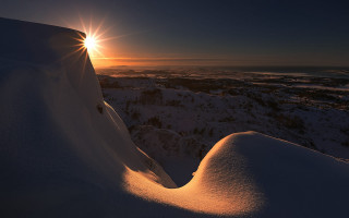 Sunset snowy mountain backlight ocean - a bright light free wallpaper