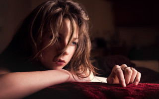 Woman leaning bed blue eyes - a dark background free wallpaper for desktop
