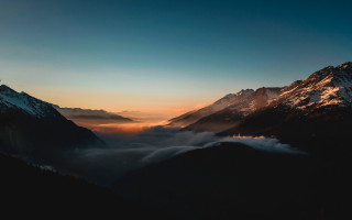 Mountain range sunset clouds reflection - the foreground and a sunset in the background free wallpaper