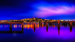 City skyline night mystical colors - a purple sky and water free wallpaper