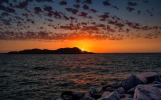 Sunset mountain reflection ocean island - a sunset over a body of water free wallpaper