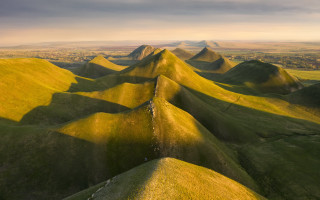 Grassy mountains cloudy sky tiltshift - a grassy area free wallpaper
