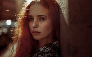 Freckled woman leaning wall serious - against a wall free wallpaper