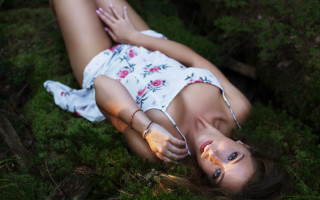 Woman lying on grass dappled - portrait photography free wallpaper