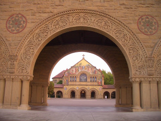 Large archway clock building clocktower - side and a building in the background free wallpaper