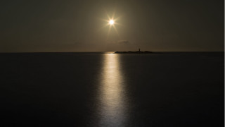 Bright sun ocean night lighthouse - a lighthouse in the distance free wallpaper