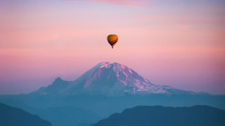 Hot air balloon mountain sunset - over a mountain range free wallpaper