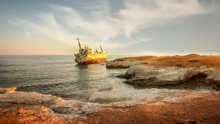 Large boat rocky shore cliff - constantine andreou free wallpaper