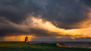 Lighthouse field stormy sky ocean - a large field free wallpaper