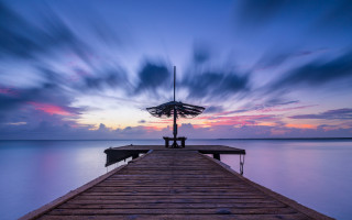 Pier umbrella person sunset clouds - a pier free wallpaper