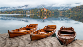 Wooden boats lake church foggy - a church in the background free wallpaper