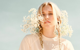Woman braids flower hat blue - a blue sky behind her free wallpaper