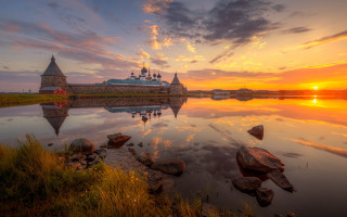 Sunset lake castle rocks grass - a sunset over a lake free wallpaper