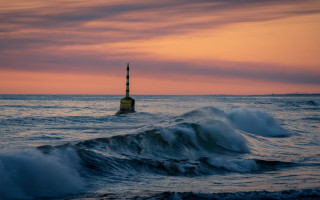 Buoy ocean sunset waves boat - a boat in the distance free wallpaper