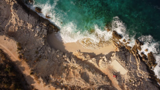 Beach water cliff red umbrella - aerial free wallpaper