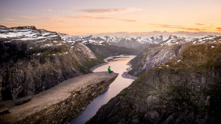 Cliff overlooking lake mountains sunset - a sky background and a person free wallpaper