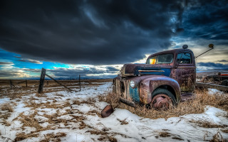 Old truck snowy field cloudy - under a cloudy sky free wallpaper