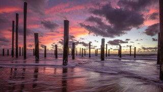Sunset pier waves poles cityscape - a few pole free wallpaper
