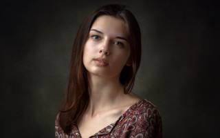 Serious woman portrait dark background - her face and shoulder free wallpaper