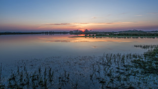 Sunset lake clouds grass building - a sunset over a lake free wallpaper