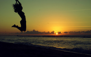 Beach sunset jumping figure ocean - the background and the ocean in the foreground free wallpaper