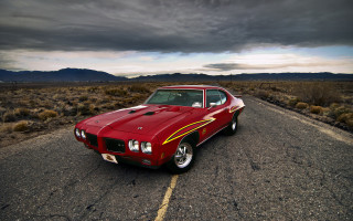Red car desert mountains cloudy - a red car free wallpaper