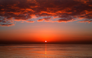 Sunset ocean boat red sky 2 - a sun setting free wallpaper