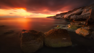 Sunset rocky beach forest mountain - the foreground and a body of water free wallpaper