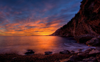 Sunset rocky beach water cliff 6 - a sunset over a rocky beach free wallpaper