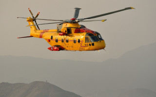 Yellow helicopter mountain range red - over a mountain range in the sky free wallpaper