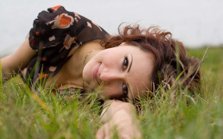 Woman laying in grass blowing - the grass free wallpaper