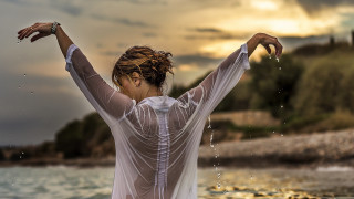 Woman beach outstretched arms water - constantine andreou free wallpaper
