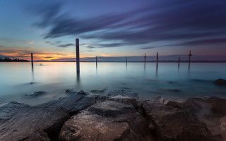 Sunset water mountains rocks boat - the foreground and a boat in the distance free wallpaper
