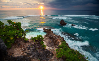 Sunset ocean rocky shore waves - a large rock free wallpaper