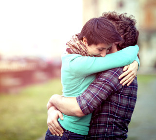 Couple hugging field grass building - free love wallpaper