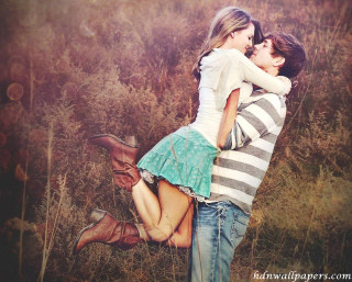 Couple hugging field grass flowers - free love wallpaper
