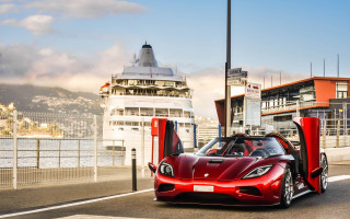 Red sports car cruise ship - a boat in the background free wallpaper