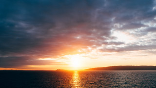 Sunset water mountain boat clouds 2 - a sunset over a body of water free wallpaper