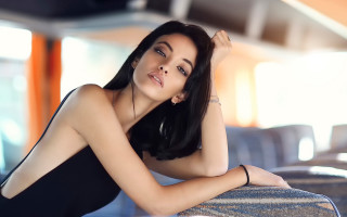Woman black dress couch portrait - her arm free wallpaper