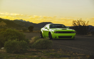 Green car mountains bushes sunset - a yellow sky free wallpaper